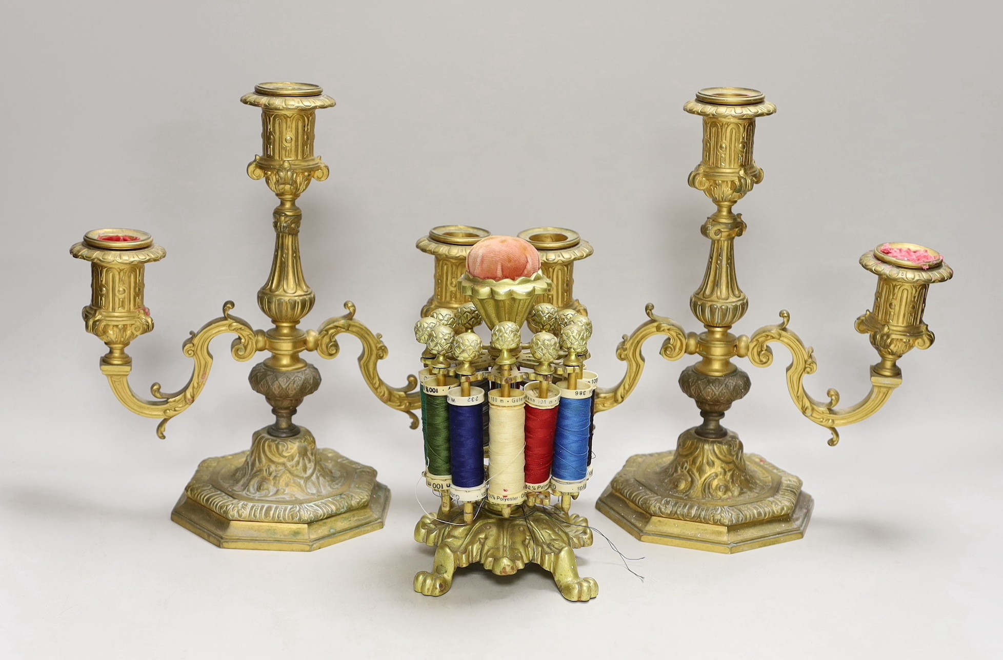 A pair of two branch three light gilt bronze candelabra and a brass cotton reel holder, candelabra 24cms high